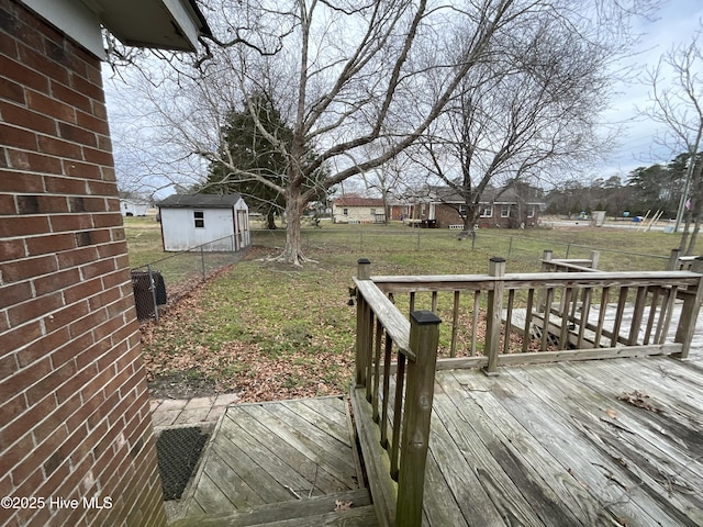 wooden terrace with a yard, an outbuilding, and fence