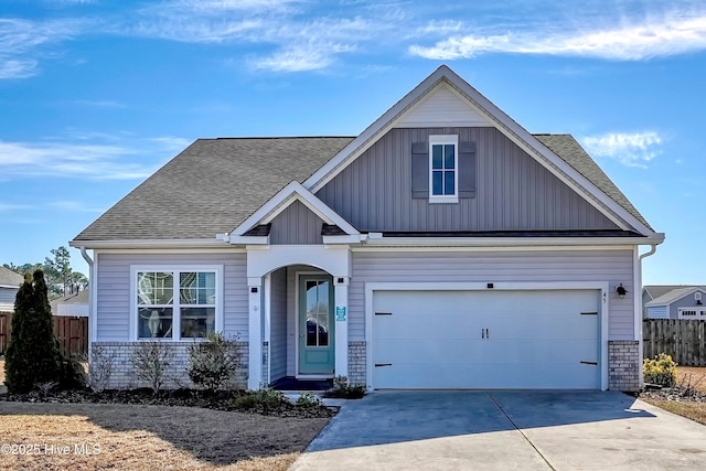 view of front facade with brick siding, fence, roof with shingles, a garage, and driveway