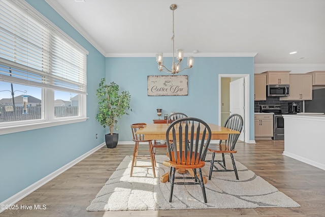 dining area featuring an inviting chandelier, baseboards, light wood-type flooring, and ornamental molding