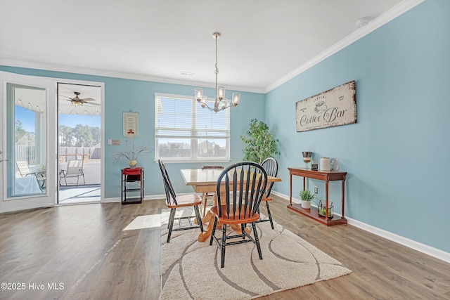 dining area featuring plenty of natural light, crown molding, baseboards, and wood finished floors