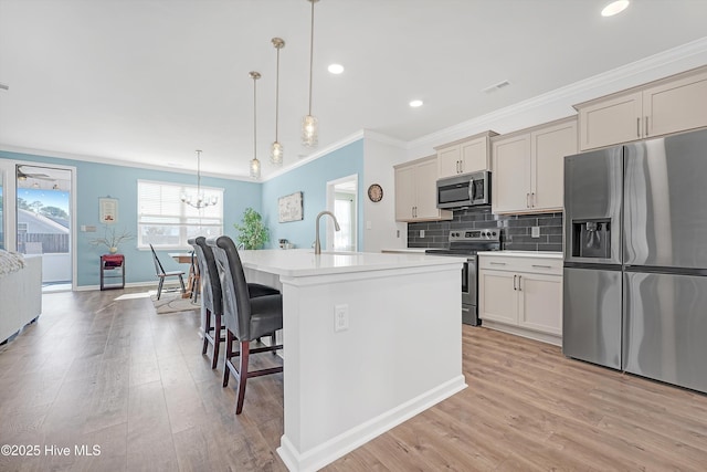 kitchen with backsplash, a breakfast bar, light wood-type flooring, light countertops, and stainless steel appliances