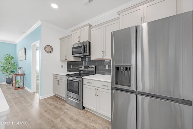 kitchen with light wood-type flooring, visible vents, appliances with stainless steel finishes, crown molding, and light countertops