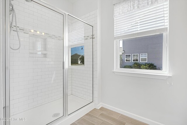 bathroom with baseboards and a stall shower