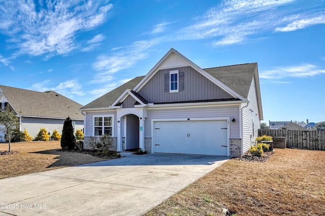 view of front of house featuring a garage, roof with shingles, driveway, and fence