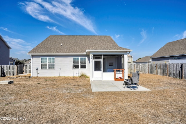 back of property featuring a patio area, a fenced backyard, a sunroom, and a lawn