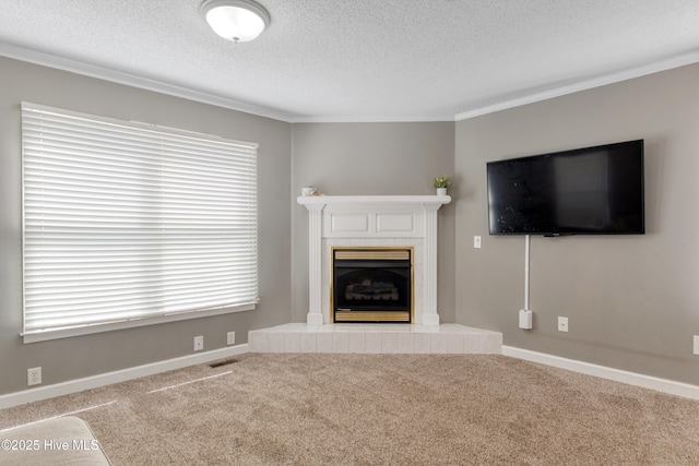 unfurnished living room featuring a fireplace, carpet, a textured ceiling, ornamental molding, and visible vents