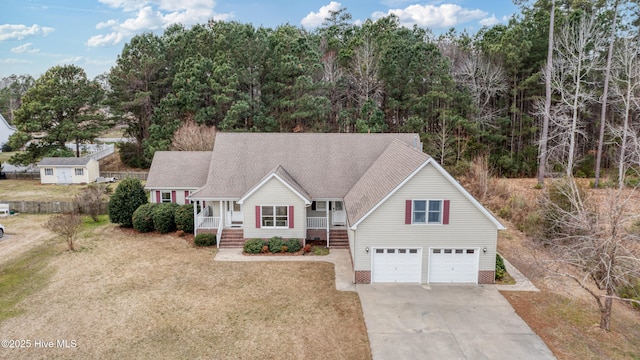 view of front facade featuring driveway, a porch, a front yard, a shingled roof, and a garage