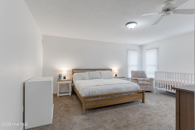 carpeted bedroom featuring a textured ceiling and ceiling fan