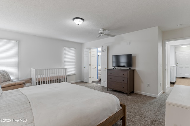 bedroom featuring a textured ceiling, carpet flooring, baseboards, and ensuite bathroom