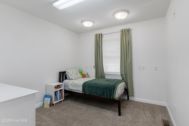 carpeted bedroom featuring visible vents, baseboards, and a textured ceiling