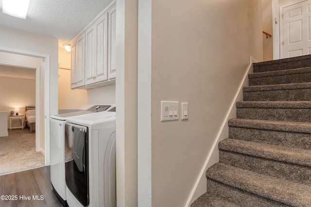 laundry room with dark wood finished floors, washer and clothes dryer, baseboards, and a textured ceiling