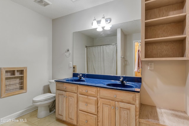 bathroom featuring a sink, visible vents, toilet, and tile patterned floors