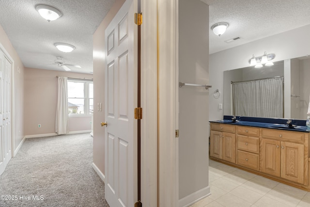 bathroom featuring visible vents, a sink, double vanity, and ceiling fan
