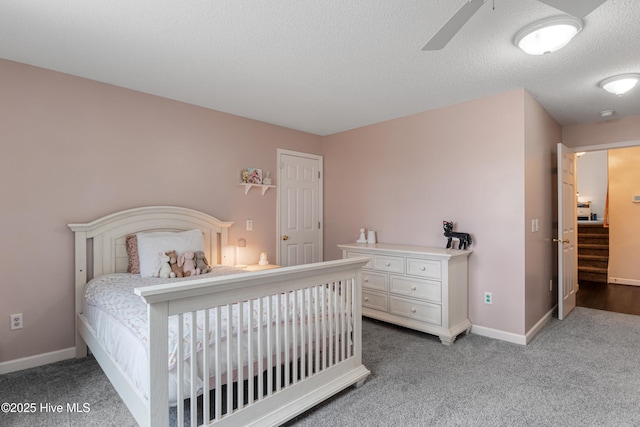 bedroom featuring ceiling fan, a textured ceiling, carpet flooring, and baseboards