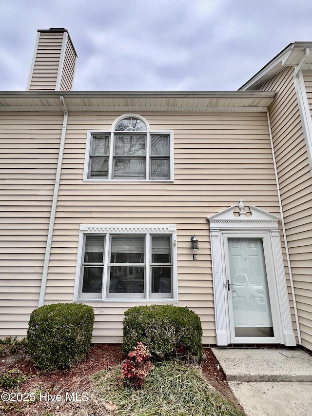 view of exterior entry with a chimney