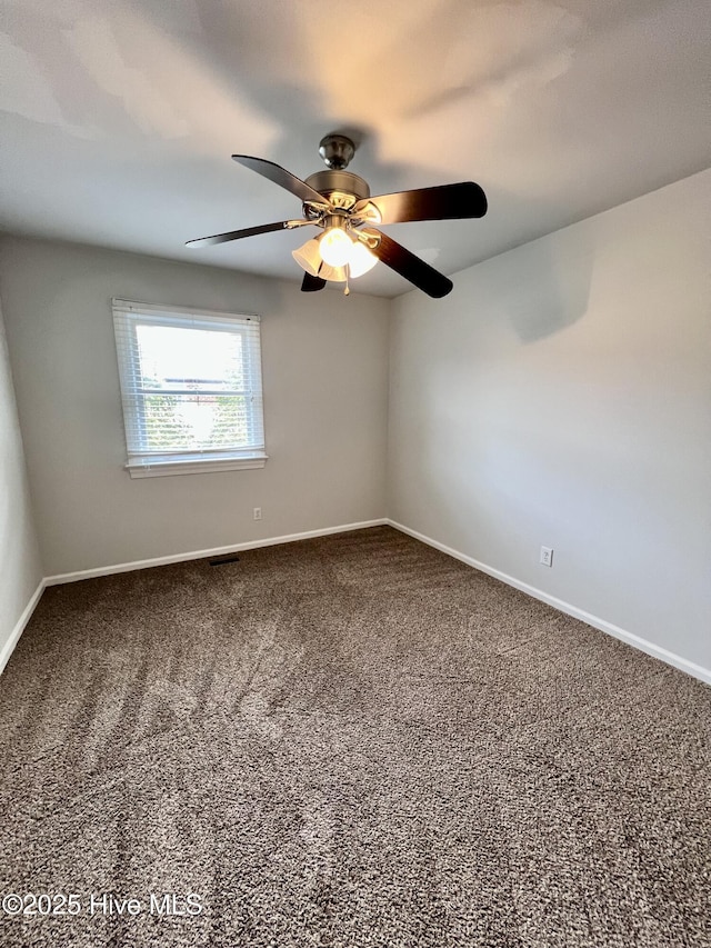 carpeted empty room with a ceiling fan and baseboards