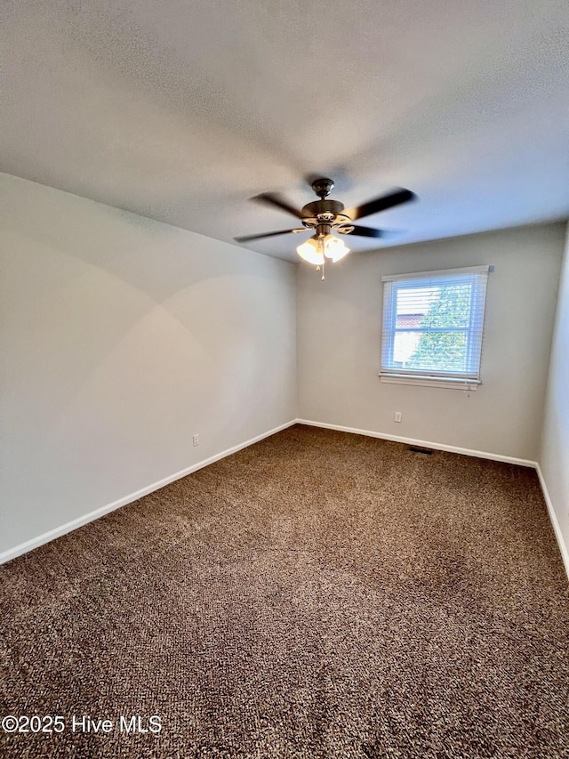 spare room featuring visible vents, baseboards, a ceiling fan, a textured ceiling, and carpet flooring