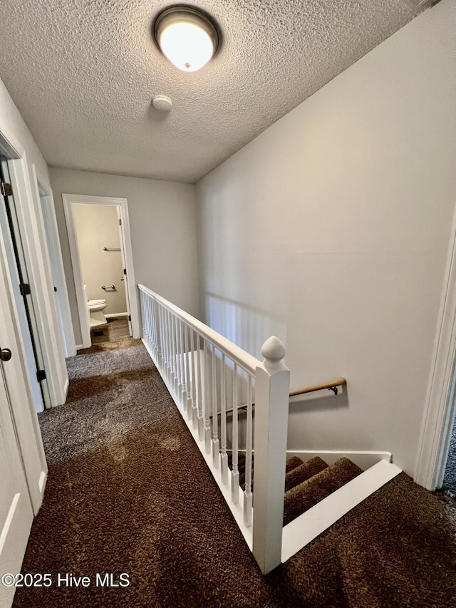 hall with a textured ceiling and carpet