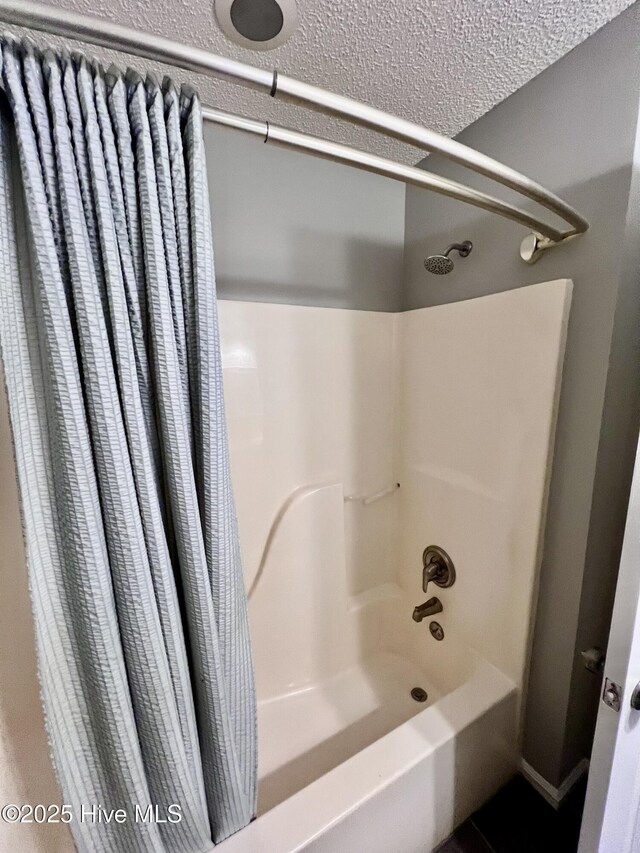 full bath featuring shower / bathtub combination with curtain and a textured ceiling