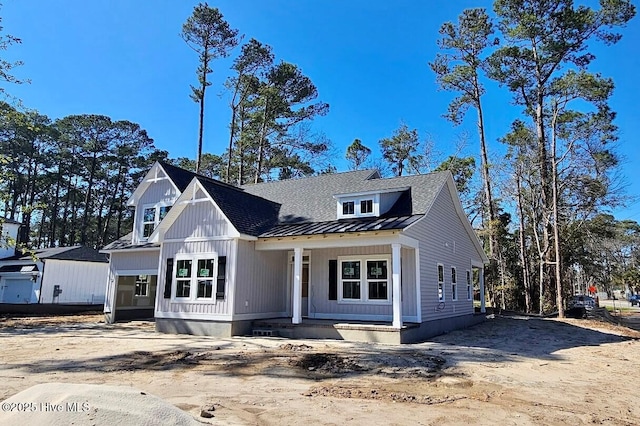 modern farmhouse with metal roof, board and batten siding, a porch, and a standing seam roof