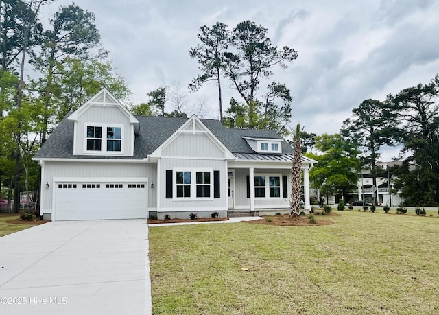 craftsman-style house featuring a front yard, a shingled roof, covered porch, and concrete driveway