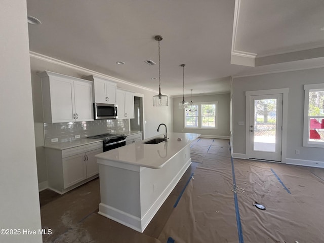 kitchen with stainless steel microwave, black electric range, a sink, and ornamental molding