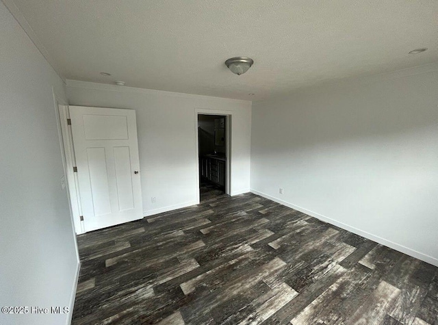 unfurnished bedroom with dark wood-type flooring, a textured ceiling, and baseboards