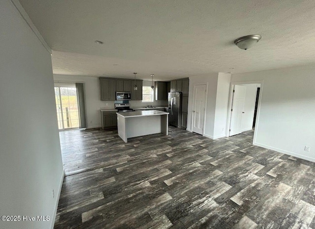 kitchen featuring stainless steel appliances, open floor plan, dark wood-type flooring, and a kitchen island