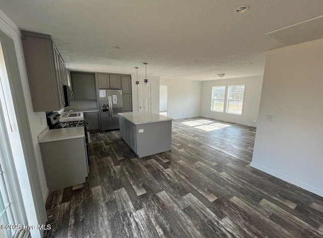 kitchen with stainless steel appliances, a center island, gray cabinets, and dark wood finished floors