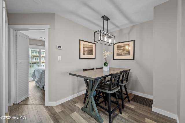 dining space featuring wood finished floors and baseboards