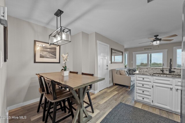 dining room featuring light wood-style flooring, baseboards, and ceiling fan