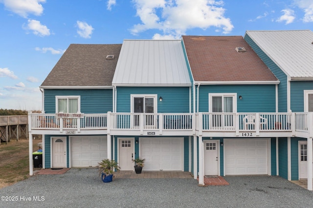 rear view of property with driveway and an attached garage