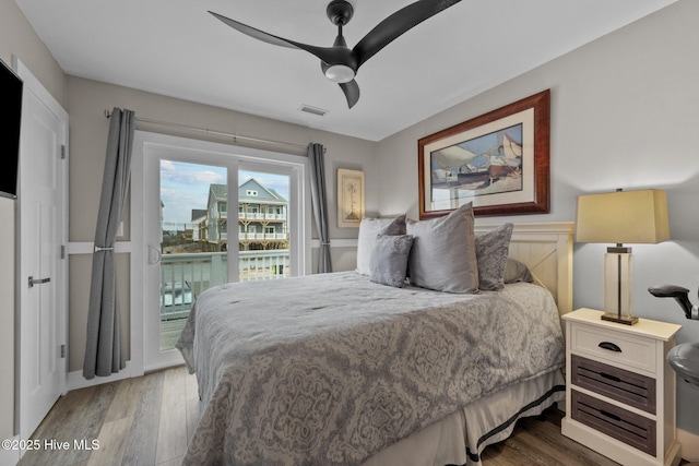 bedroom with access to outside, wood finished floors, and a ceiling fan