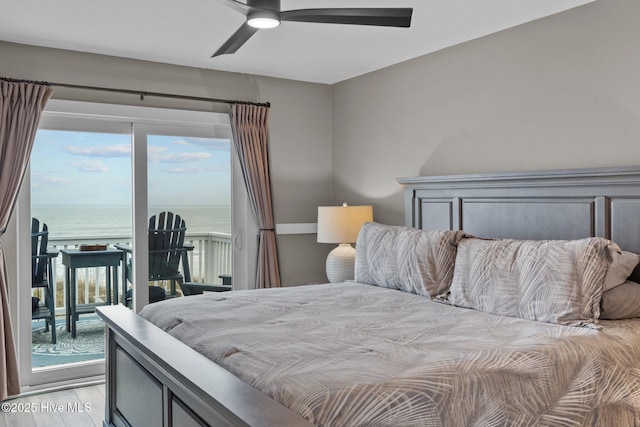 bedroom with a water view, access to exterior, light wood-style flooring, and ceiling fan