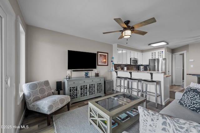 living room featuring light wood-style floors, ceiling fan, and baseboards