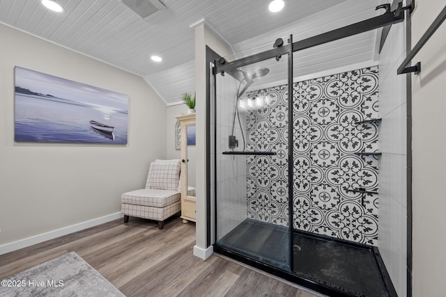 bathroom with lofted ceiling, a stall shower, baseboards, and wood finished floors