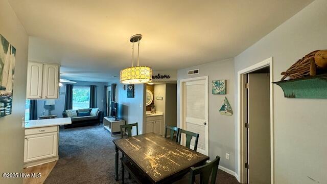 dining room featuring visible vents and dark colored carpet