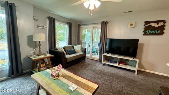 living area featuring carpet flooring, visible vents, a ceiling fan, and baseboards