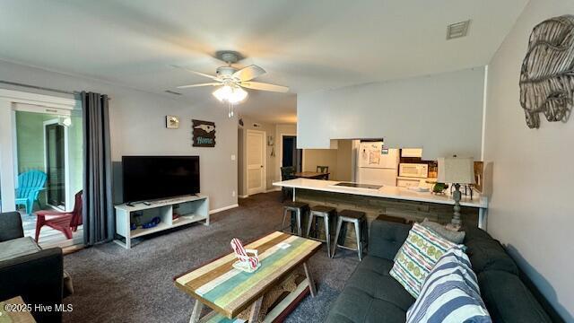 living room with visible vents, ceiling fan, and carpet