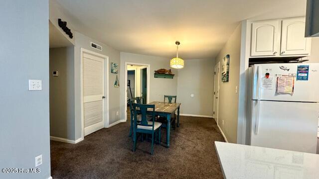 dining area with dark colored carpet, visible vents, and baseboards