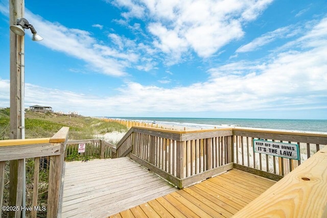 deck with a view of the beach and a water view