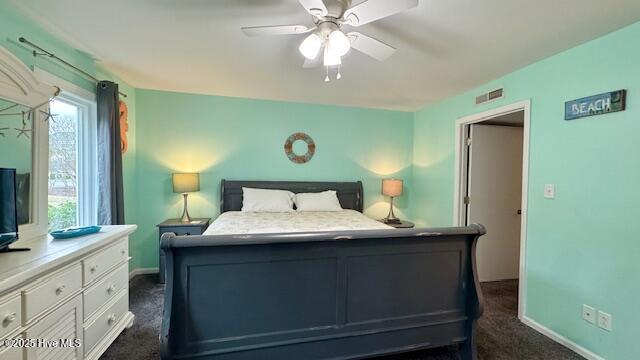 bedroom featuring dark carpet, a ceiling fan, and baseboards