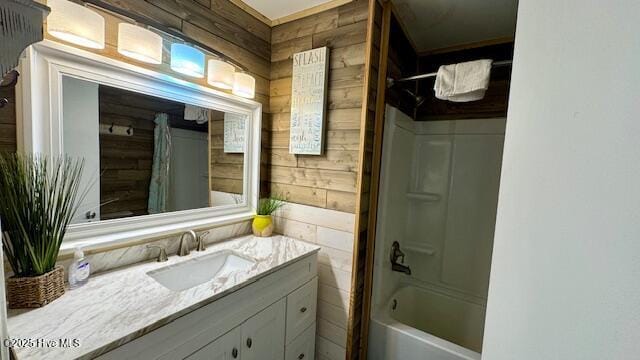 bathroom with wooden walls, tub / shower combination, and vanity