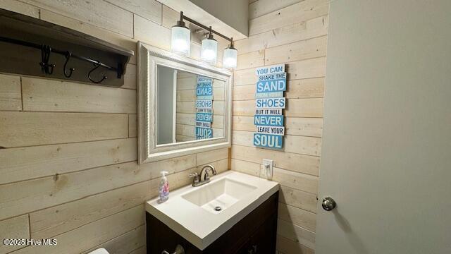 bathroom featuring wood walls and vanity