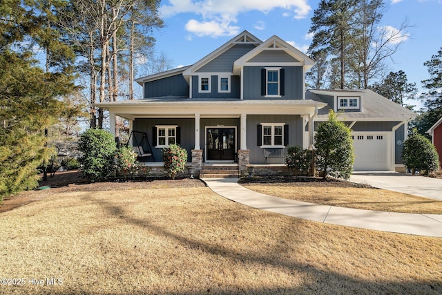 craftsman-style home featuring board and batten siding, a front lawn, a porch, driveway, and an attached garage