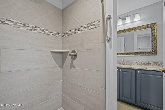 bathroom with vanity and a tile shower