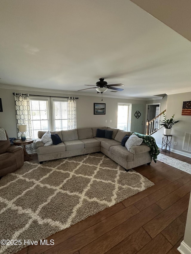 living area with crown molding, stairway, a ceiling fan, wood finished floors, and baseboards