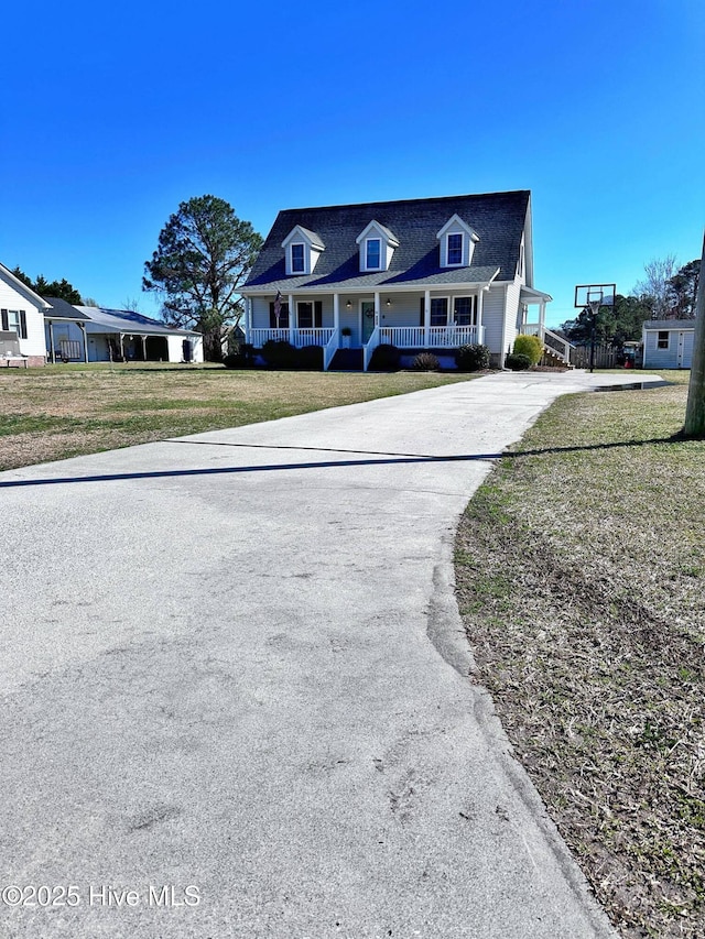 cape cod-style house featuring covered porch and a front yard