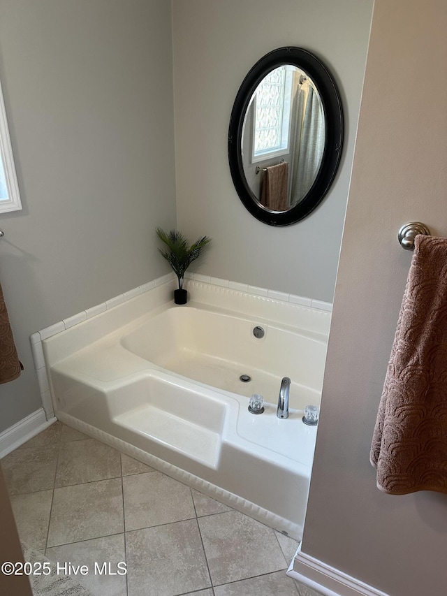 bathroom featuring baseboards, a bath, and tile patterned floors