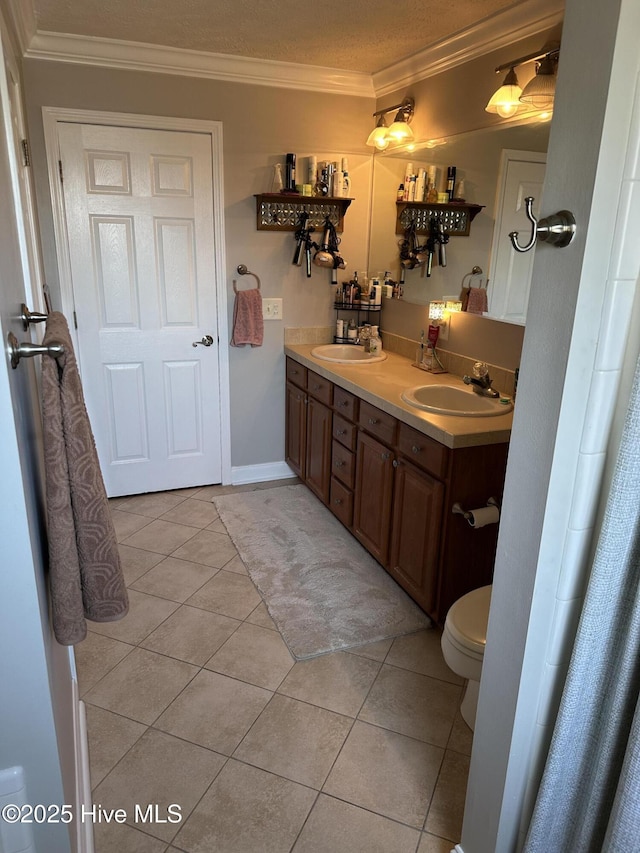 bathroom with crown molding, a sink, and tile patterned floors